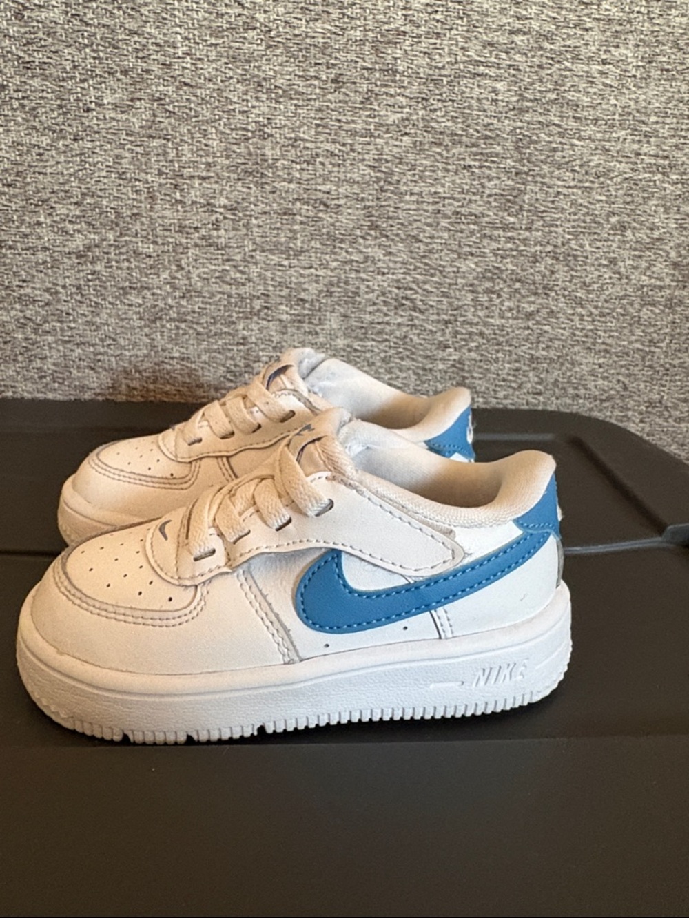 Nike Kids White Sneakers with Blue Swoosh.